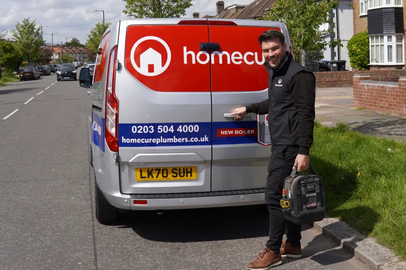 Our highly skilled plumber standing next to a Homecure van
